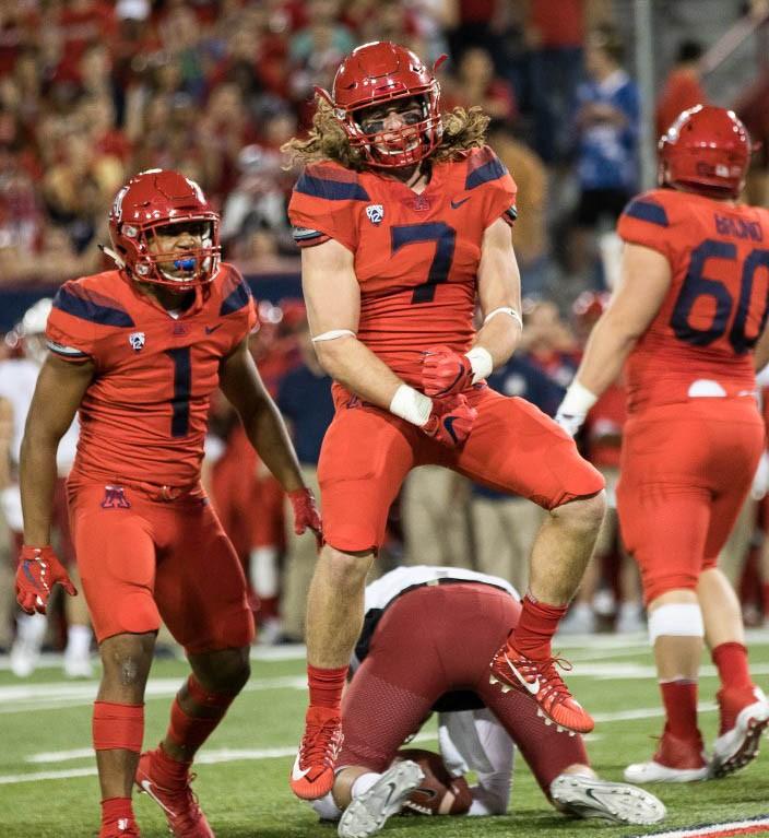 Arizona 's Colin Schooler flexes after taking down a Washington State player during the UA-Washington State game on Saturday, October 28, 2017.