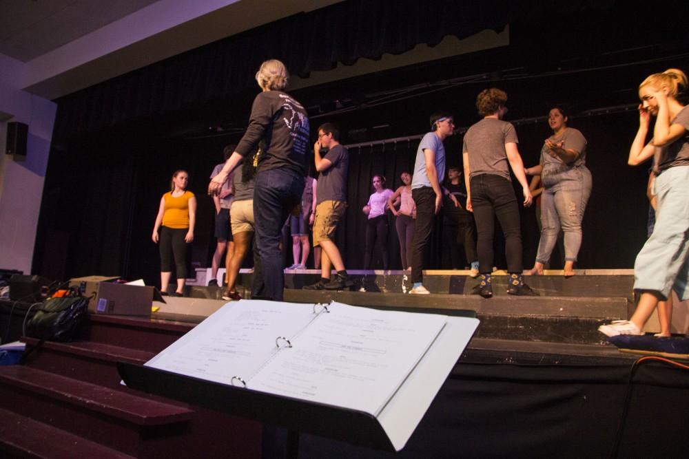 Dana Milne, Director,  steps onto the stage to show her actors how she wants them to perform during a rehearsal of Big Fish at Salpointe High School on June 9.