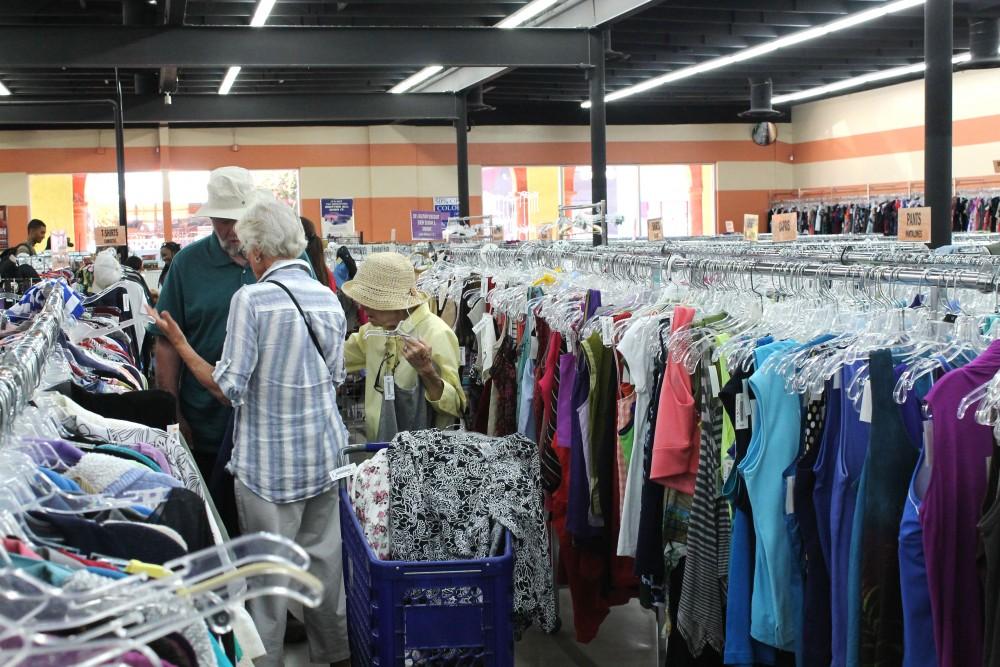 Customers shopping at the fourth ave Goodwill look through blouses. The store gives discounts to its customers from weekly deals to daily deals. 