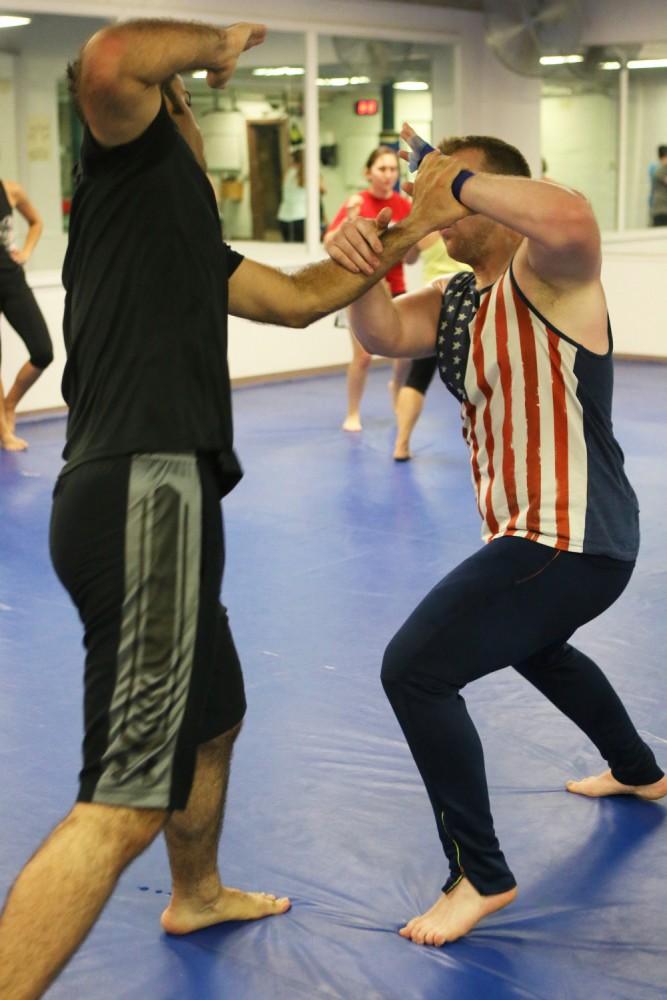 Chavoosh Ghasemi, left, spars with Michal Hillin, right, during high-intensity warm-up drills. Krav Maga, unlike many other martial art forms, emphasizes defensive moves and blocks more than attacking strikes.