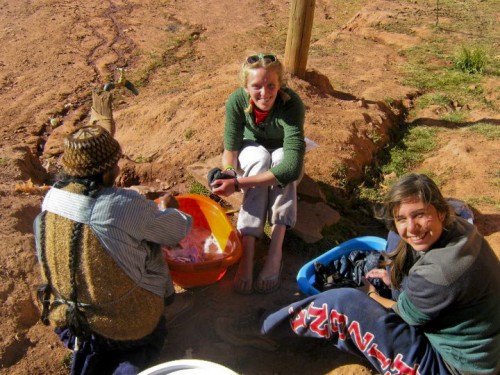 Systems engineering junior Lizzie Greene, center, and hydrology senior Chelsea Kestler, right, wash their clothes in buckets with a native woman in Marquirivi, Bolivia. Engineers Without Borders is replacing plumbing infrastructure for the village, and is currently in the project's design phase.