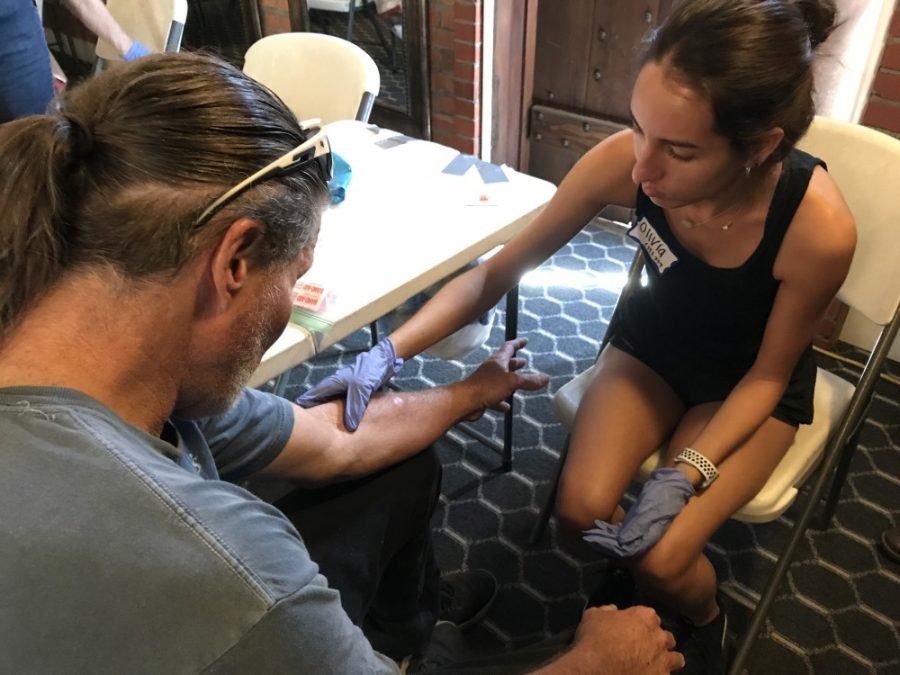 Senior public health student Olivia Sandhu is examining the arm of Jimbo, a 59-year-old homeless man who has an abscess from injecting the Smurf form of methamphetamine. Sandhu and students like her spent Sunday, Sept. 16 at Z Mansion in Downtown Tucson. 