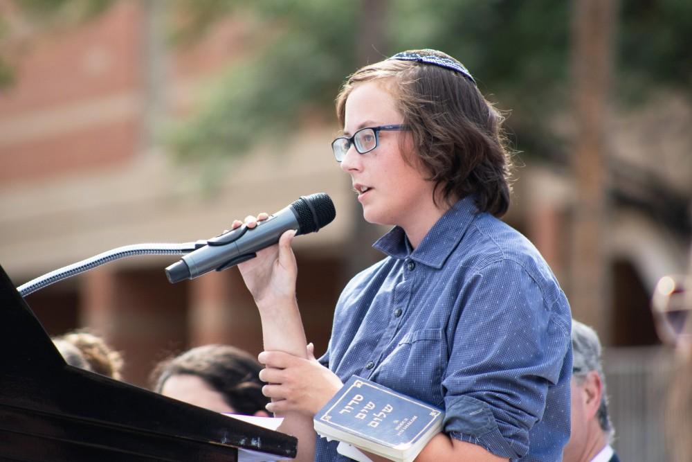 Eri, the Director of Jewish Studies at the University of Arizona, recites the Mourner's Kaddish, a traditional Jewish prayer, during the vigil for the victims of the recent synagogue shooting. The vigil was organized by Hillel, a Jewish organization on campus. 