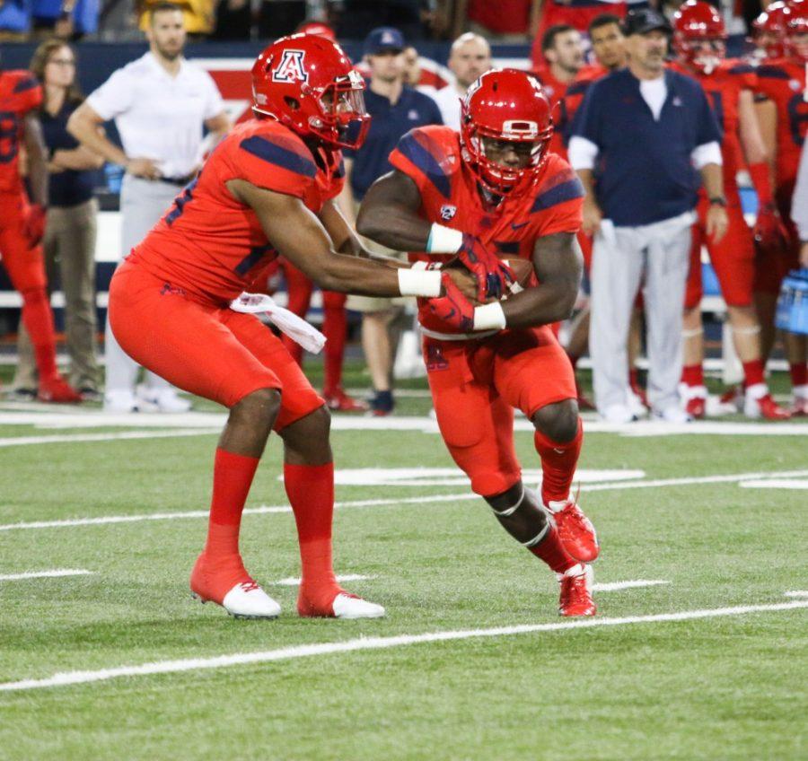Quarterback Khalil Tate (14) hands the ball over to running back JJ Taylor (21) during the homecoming game against Oregon on Saturday, Oct. 27 at Arizona Stadium. 