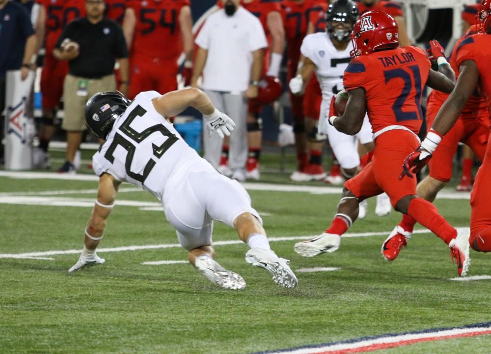 Running back JJ Taylor rushes the ball and avoids getting tackled during the homecoming game against Oregon on Saturday, Oct. 27 at Arizona Stadium. 