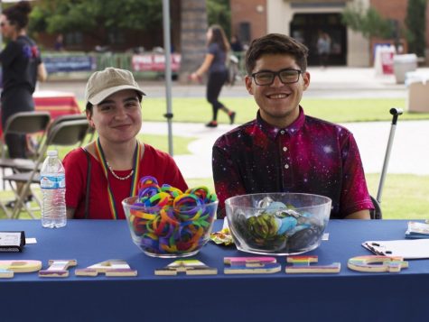 Students Vanessa L. (left) and Garrett E. (right) run the LGBTQ Affairs booth on National Coming Out Day. The resource fair celebrates LGBTQ acceptance and pride, providing useful information for students.