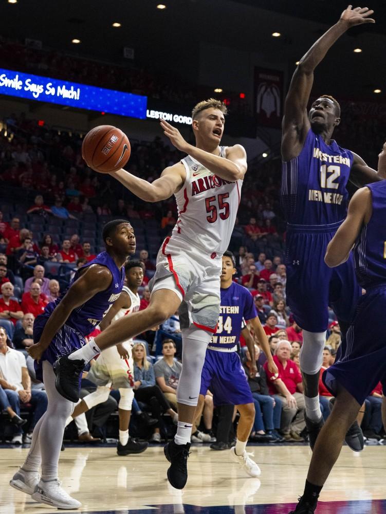 Arizona's Jake DesJardins, 55, passes the pass through a crowded area during the Arizona-West New Mexico University game on Tuesday, Oct. 30 at the McKale Center in Tucson, Ariz.