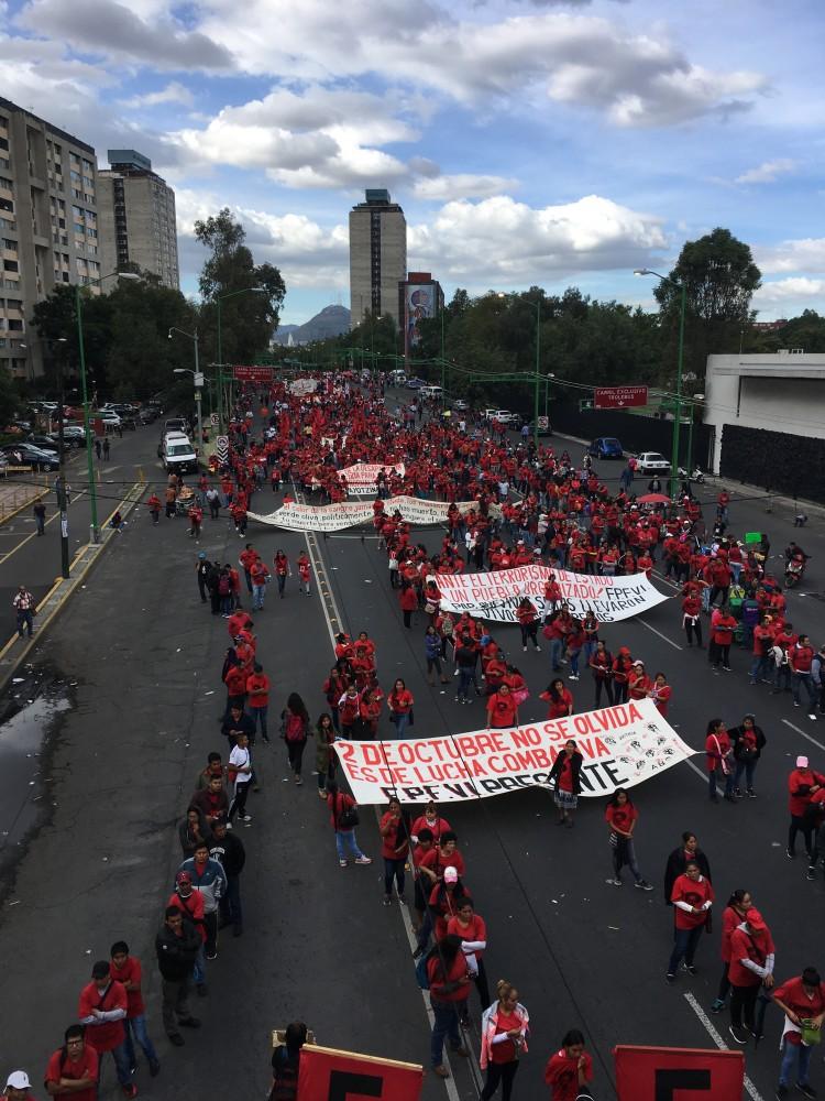 Dressed in red, members of El Frente Popular Fransisco Villa, the Fransisco Villa Popular Front, participated in the march for the 50th anniversary of the 1968 student movement Tlatelolco massacre. The Marxist organization carried banners reading, "Do not forget the 2nd of Oct.,  it's the combative struggle."