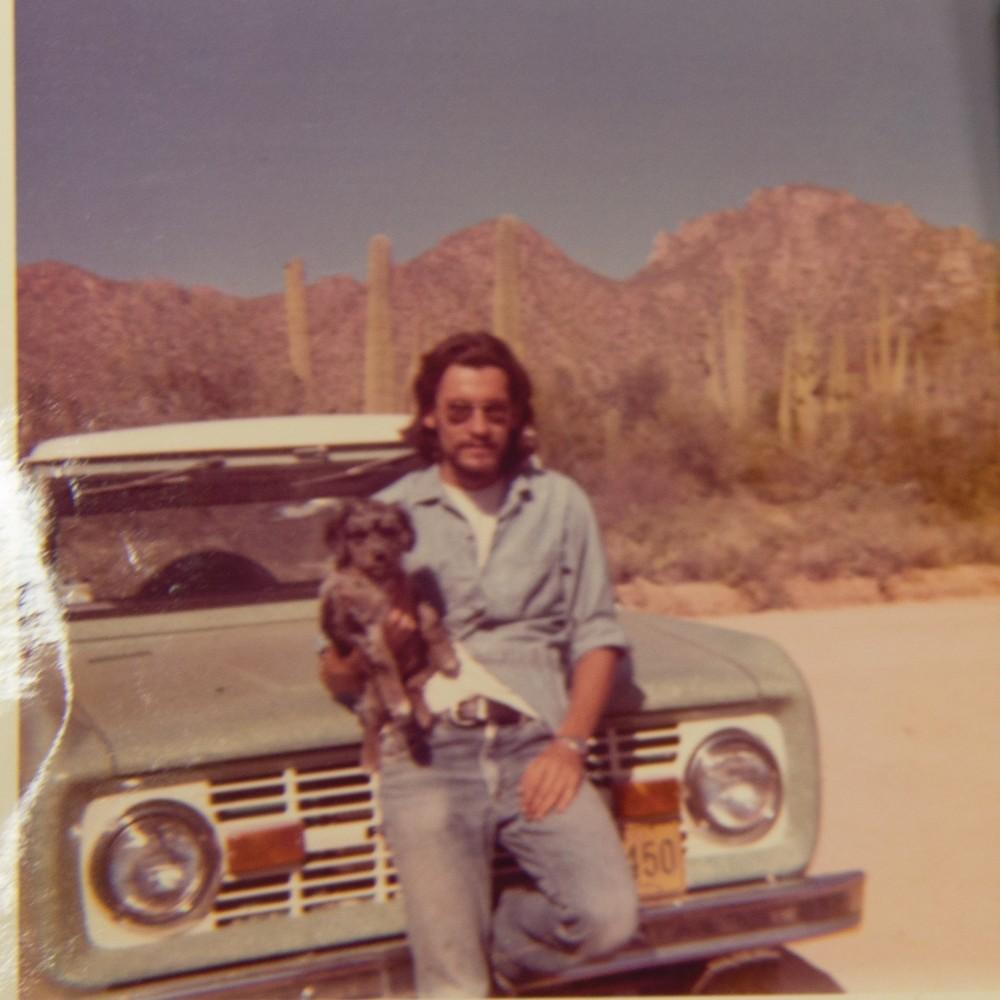 Robert Skarda stands with his dog in front of his Ford pickup truck in the Tucson desert.