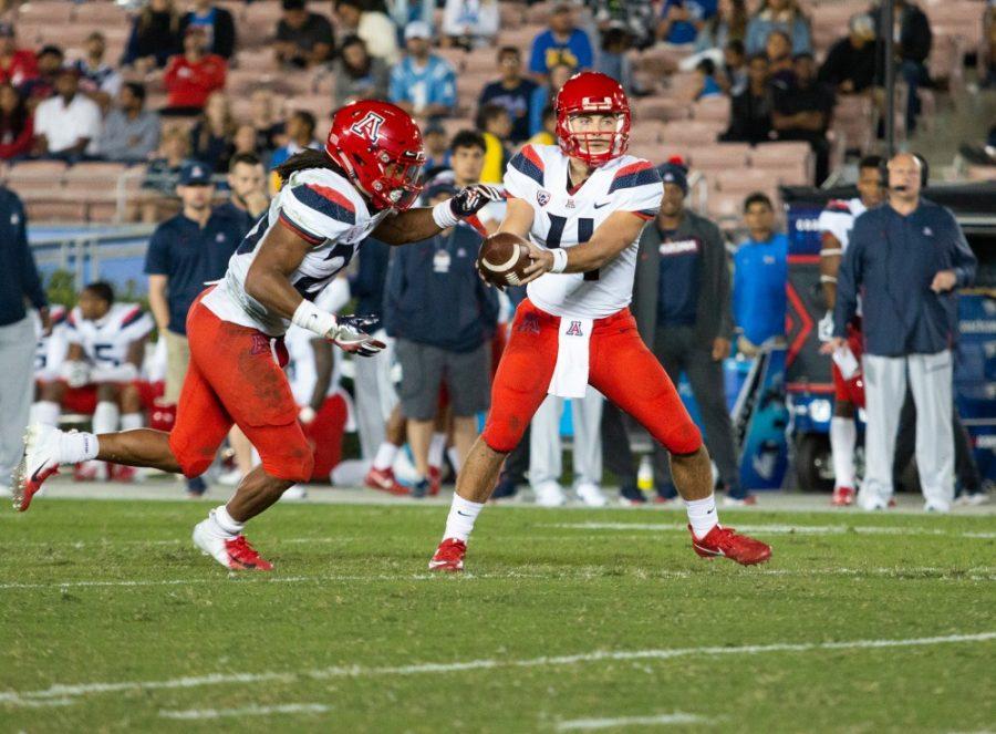 Quarterback Rhett Rodriguez (4) passes the ball to Running Back Gary Brightwell (23) during the game against UCLA on Saturday, Oct. 20 at the Rose Bowl. UA lost with a score of 31-30. 