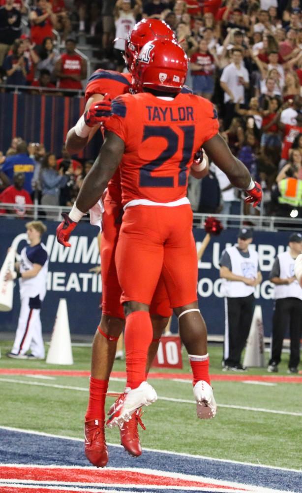 JJ Taylor (21) celebrates with his teammate after scoring a touchdown to increase the lead for UA during the homecoming game against Oregon on Saturday, Oct. 27 at Arizona Stadium