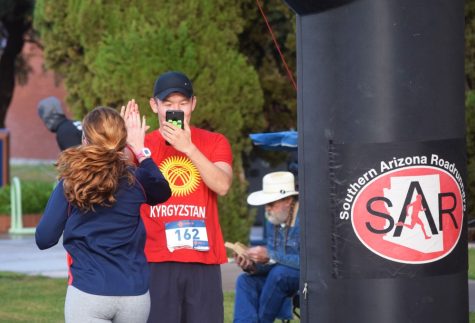 A runner congratulates another runner crossing the finish line during the race on October 14. The Jim Click’s Run n Roll race raises money for the University of Arizona Disability Resource Center.