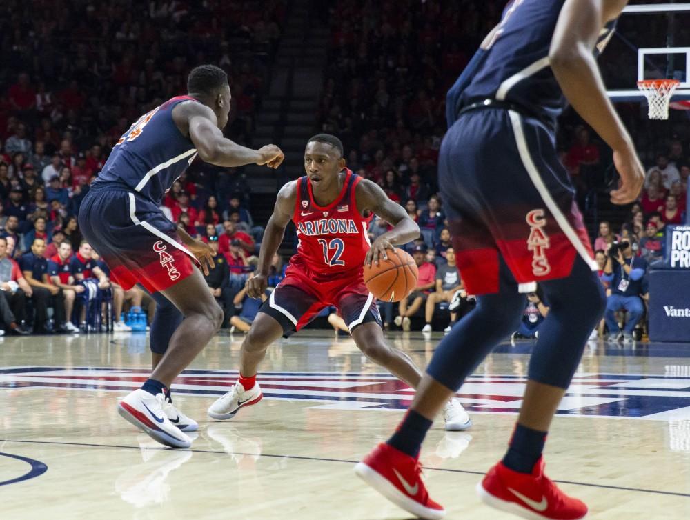 Arizona's Justin Coleman, 12, looks across the court to find somewhere to pass the ball during the Red-Blue game on Sunday, Oct. 14 at the McKale Center in Tucson, Ariz.