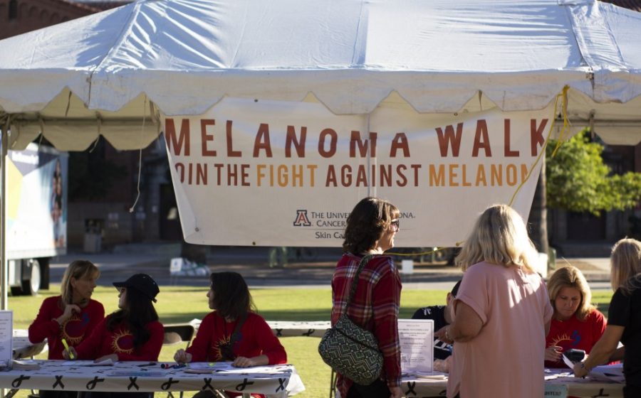 People gather at the sign up booth to participate in the 2018 Melanoma Walk. The walk was organized by the University of Arizona Cancer Center and featured many booths, including a cancer screening tent.