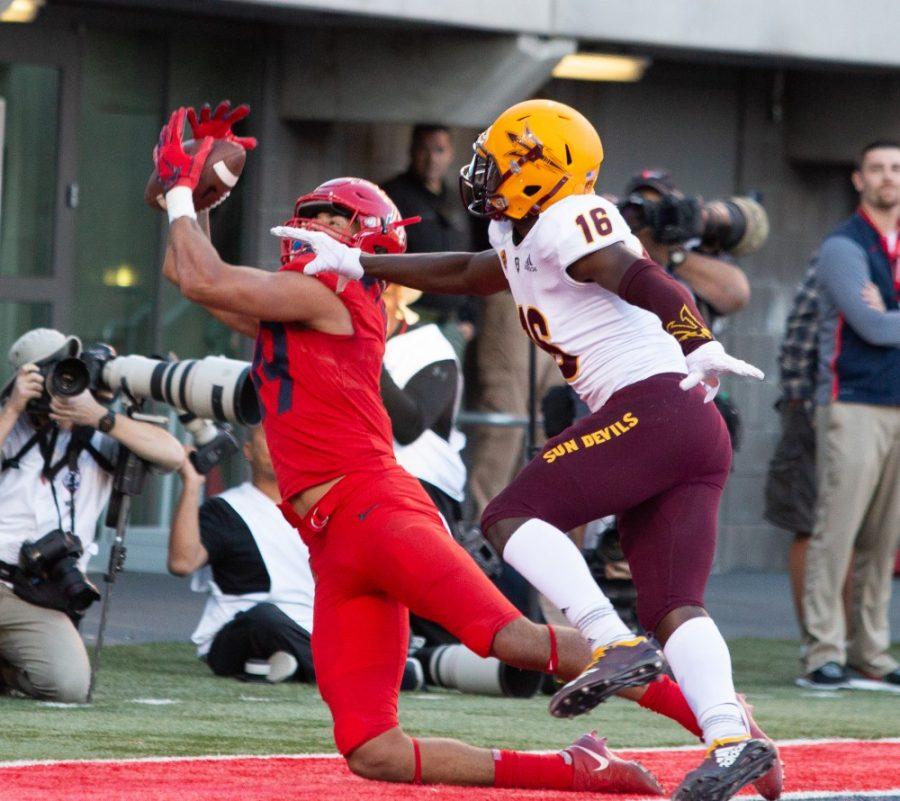 Wide Receiver Shawn Poindexter (19) reaches to catch a pass during the game against ASU on Saturday, Nov. 24 at Arizona Stadium. Arizona did not win the territorial cup and was defeated by ASU with a final score of 41-40. 