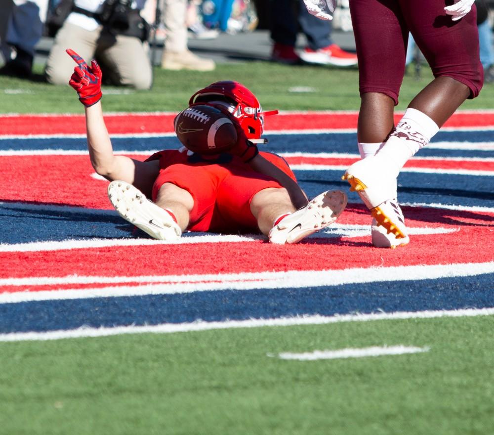 Wide Receiver Tony Ellison (9) lays in the end zone and points after scoring a touchdown to increase Arizona's lead over ASU during the game on Saturday, Nov. 24 at Arizona Stadium. 