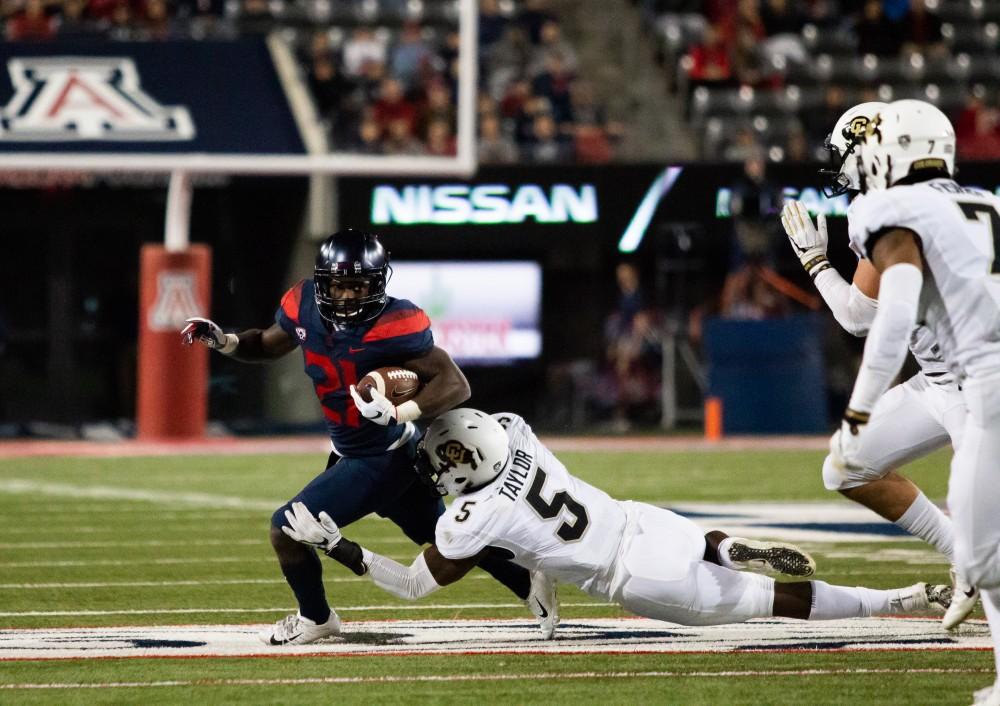 Running back J.J. Taylor (21) tries to dodge Colorado's defensive and give Arizona another first down. The final score of the Arizona-Colorado game at Arizona Stadium on Nov. 2, 2018 in Tucson Az was 42- 34.