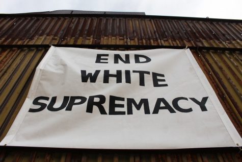 Artist Sadie Shaw decided to make a statement by placing the "End White Supremacy" sign in the middle of Taller Yonke's art piece by Harvill building, as a response to a paper she found taped on the art piece a few weeks ago.