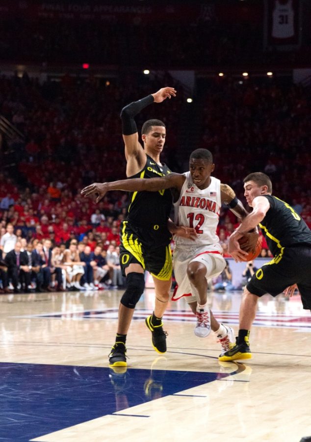 Wildcat Justin Coleman (12) gets the ball stolen from him by the Oregon defense during the Arizona-Oregon game on Thursday Jan. 17 at McKale Center in Tucson Ariz.