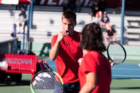 The Arizona men's tennis team's sophomore Carlos Hassey watches as his partner celebrates after scoring in their first match on Jan. 20.
