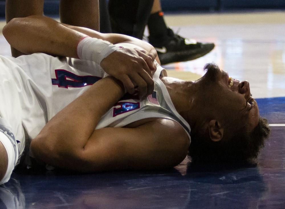 Arizona's Chase Jeter holds his wrist in pain after falling hard during the Arizona-Oregon State game on Saturday, Jan. 19, 2019 at the McKale Center in Tucson, Ariz.