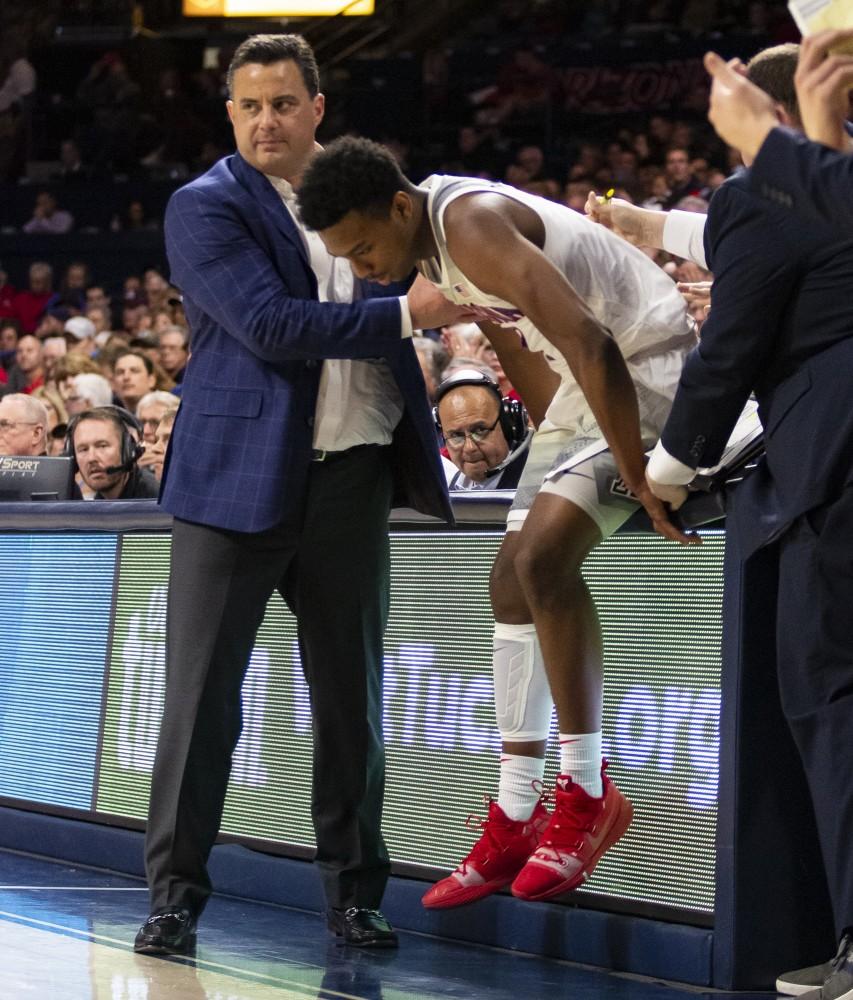 Arizona Men's Basketball Head Coach, Sean Miller, helps Brandon Williams (2) up from the media table after Williams made a wild save during the Arizona-Stanford game on Sunday, Feb. 24, 2019 at the McKale Center in Tucson, Ariz.