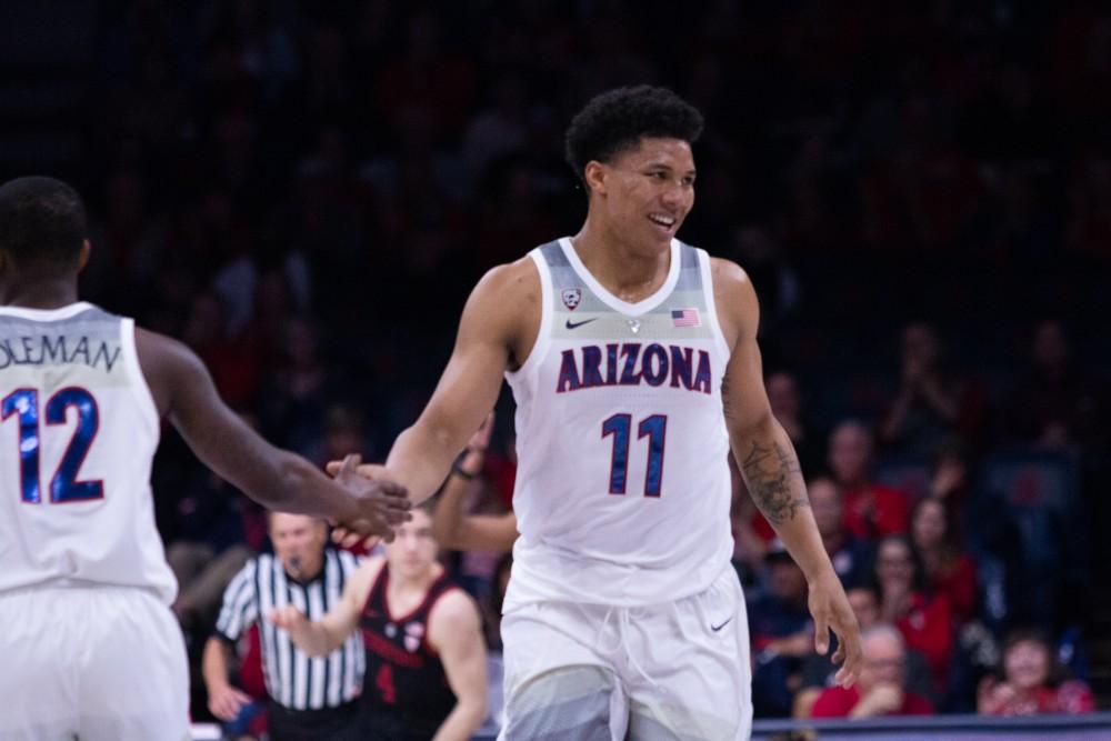 Forward Ira Lee (11) high fives Justin Coleman (12) after dunking the ball and scoring two points during the game against Stanford on Sunday, Feb. 24 at McKale Center. Arizona beat Stanford 70-54. 