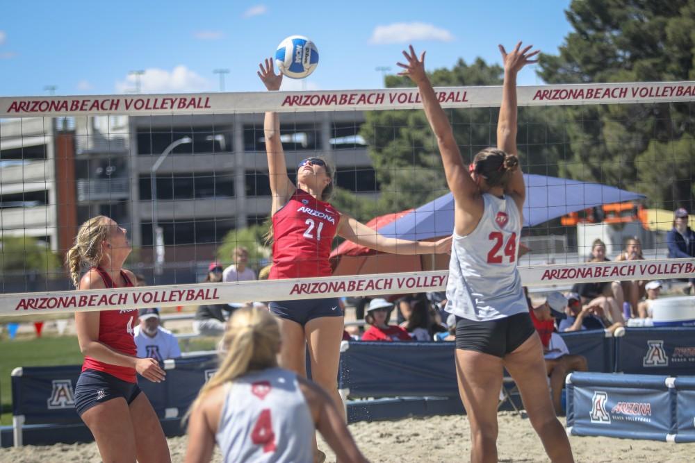 Sarah Blacker (21) spiking the ball while Jasmine Safar (4) is ready to back her up on April 13 at Bear Down Bear, in Tucson, Ariz. Arizona wins 4-1 against New Mexico. 
