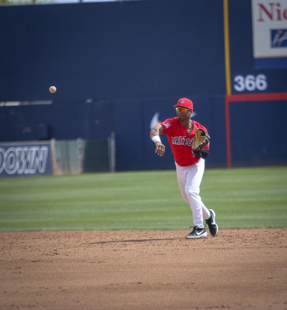Tucson Ariz.- infielder, Justin Wylie (12) throwing the ball to get an out on first base Sunday April 14, 2019 at Hi Corbett Field. Arizona wins 4-2 in the series finale against the California Golden Bears. 