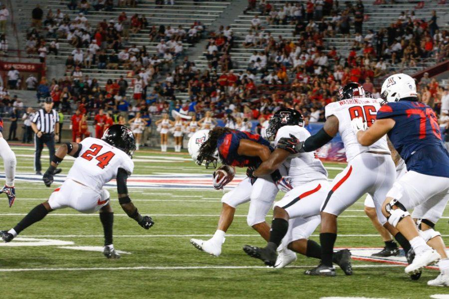 Running back, Gary Brightwell (23), grasping the ball as Texas Tech attempts a tackle. Saturday nights game ended with a score of 28-14 making the Wildcats 2-1. 