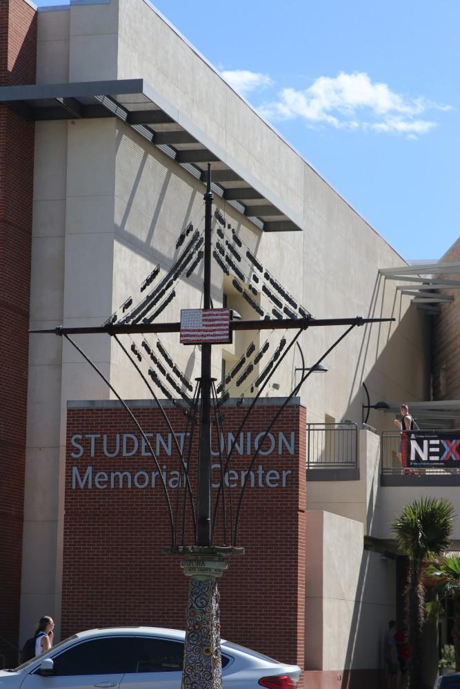 At the front of the Student Union Memorial Center stands a sculpture with the dog tags of fallen U.S.S. Arizona soldiers and an American flag. 
