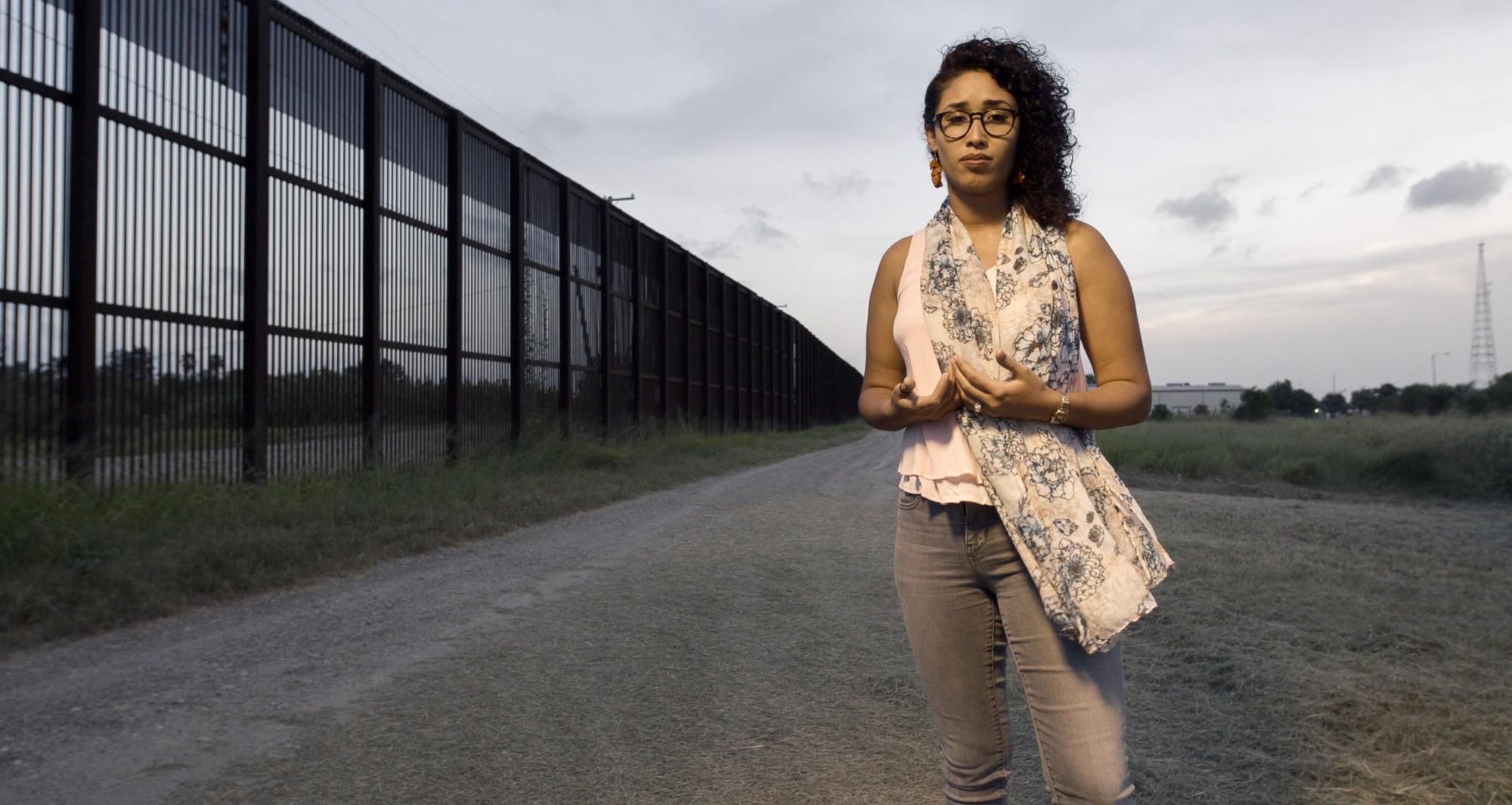 Rossy Lima recites a poem at the U.S.-Mexico border wall in Brownsville, Texas. 