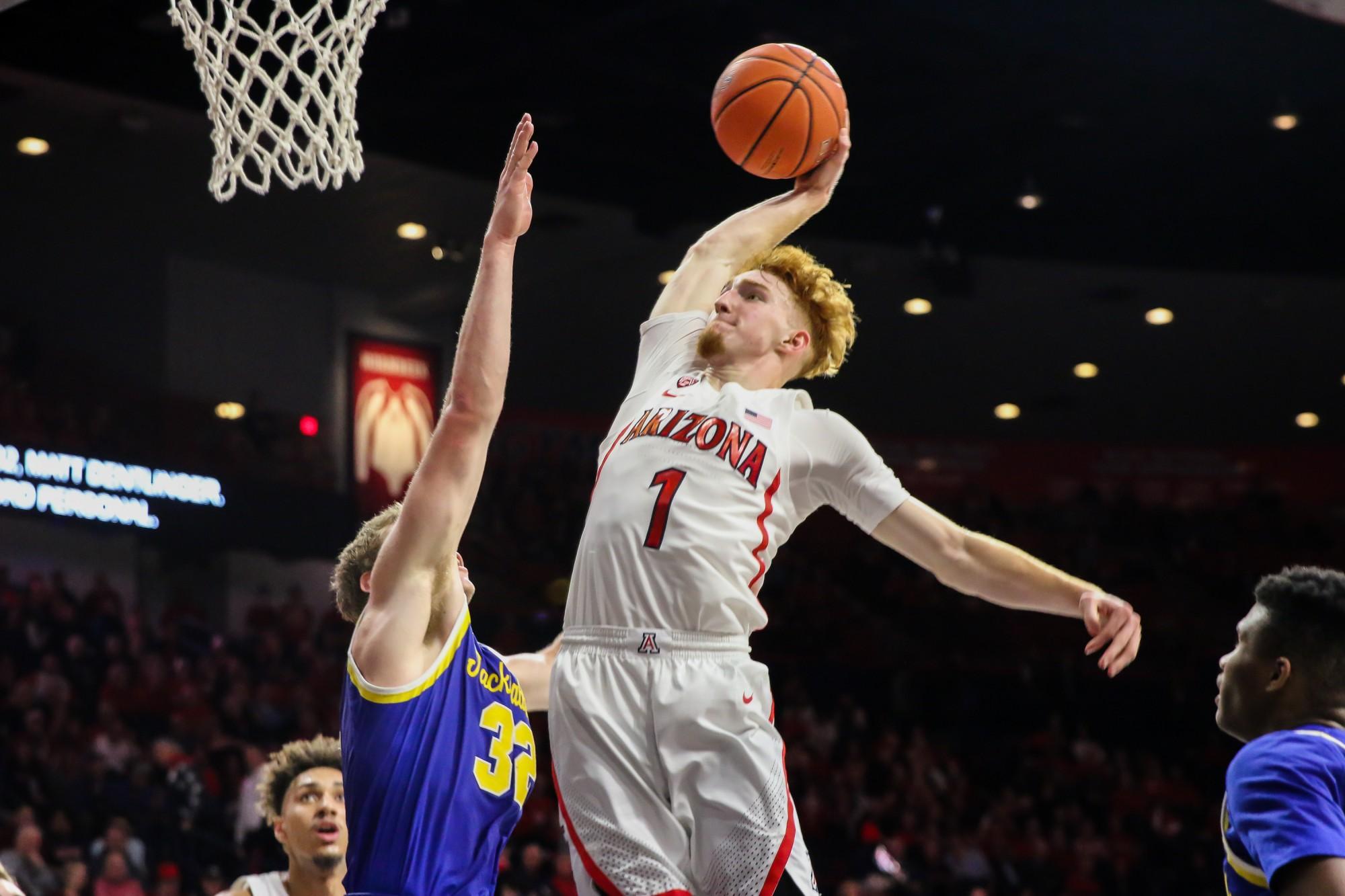 Arizona point-guard Nico Mannion (1) jumps up and dunks the ball near the end of the last half. 