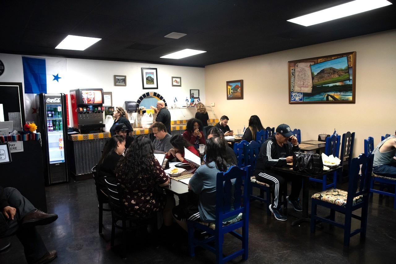 A group of customers look at the menu while munching on chips and salsa at Selena's Salvadorian.