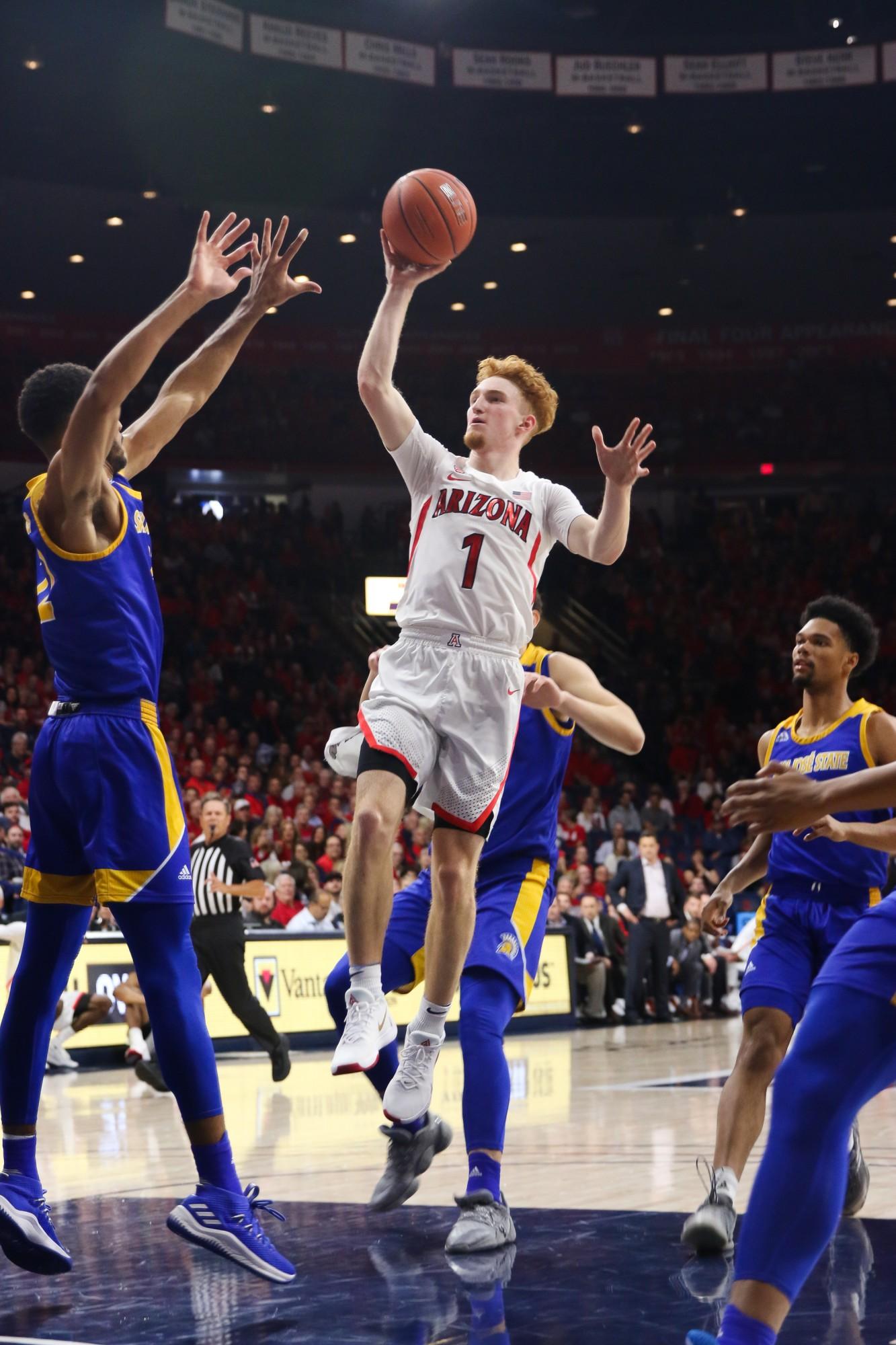 Nico Mannion (1) jumps up and shoots the ball into the basket. 