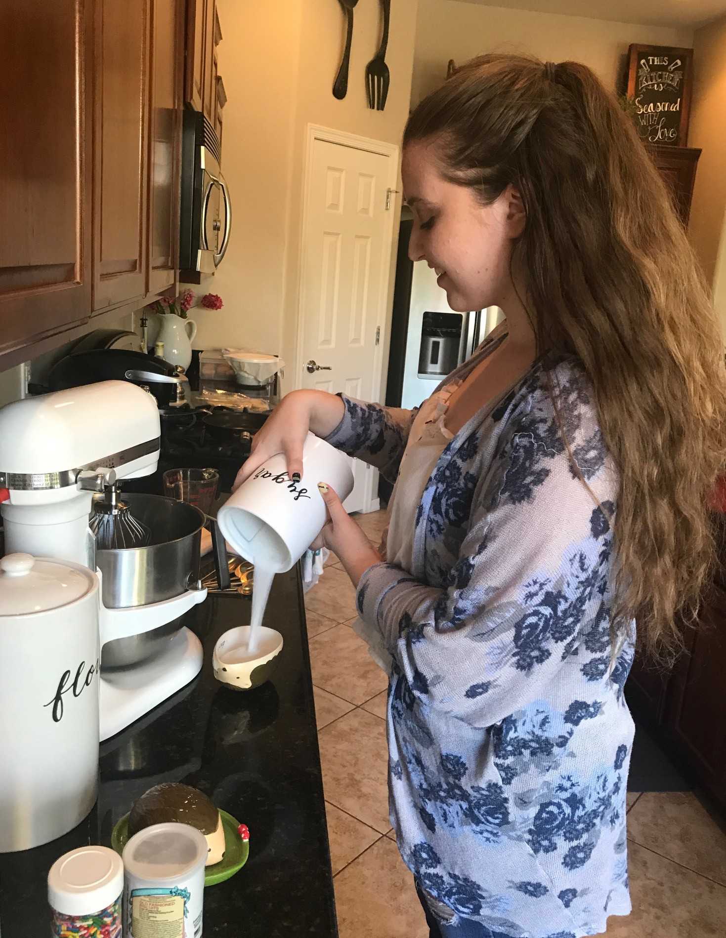 Kayla Lancaster carefully pours sugar into her cakew recipe, while baking in her home kitchen. Lancaster is the owner of Tastebuds Bakery and currently attends the University of Arizona. 