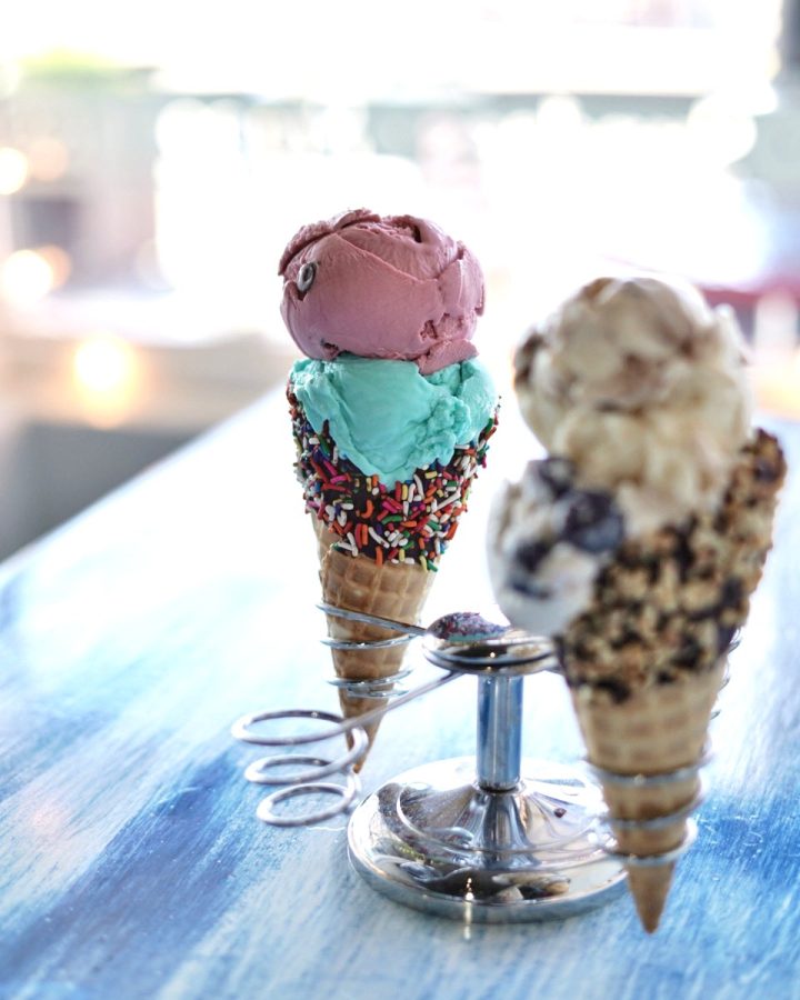 Two specialty cones; (left to right) Black Raspberry with chocolate chips, Blue Moon ice cream in a sprinkles waffle cone. Coyote tracks with a scoop of Blueberry Lavender cheesecake.