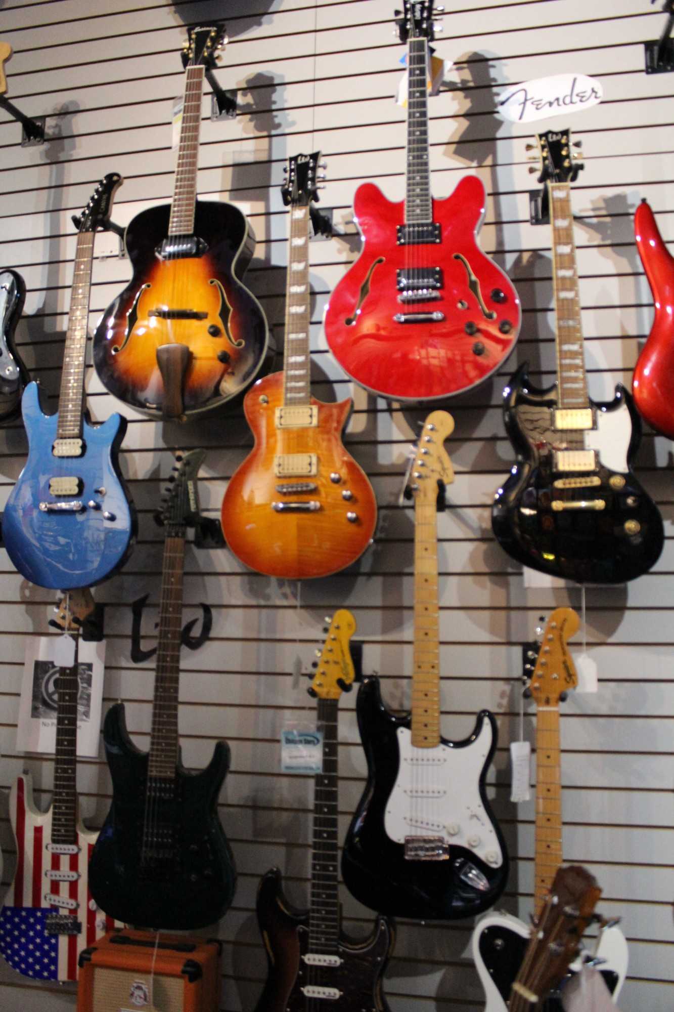 Different brands of electric guitars such as Vintage, Ibanez, and Fender.