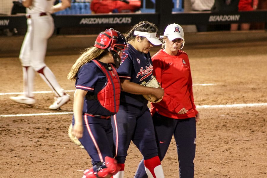 Arizona pitcher Mariah Lopez (42) talks with her teammate and assistant coach Taryne Mowatt-McKinney at the start of the a new inning. 