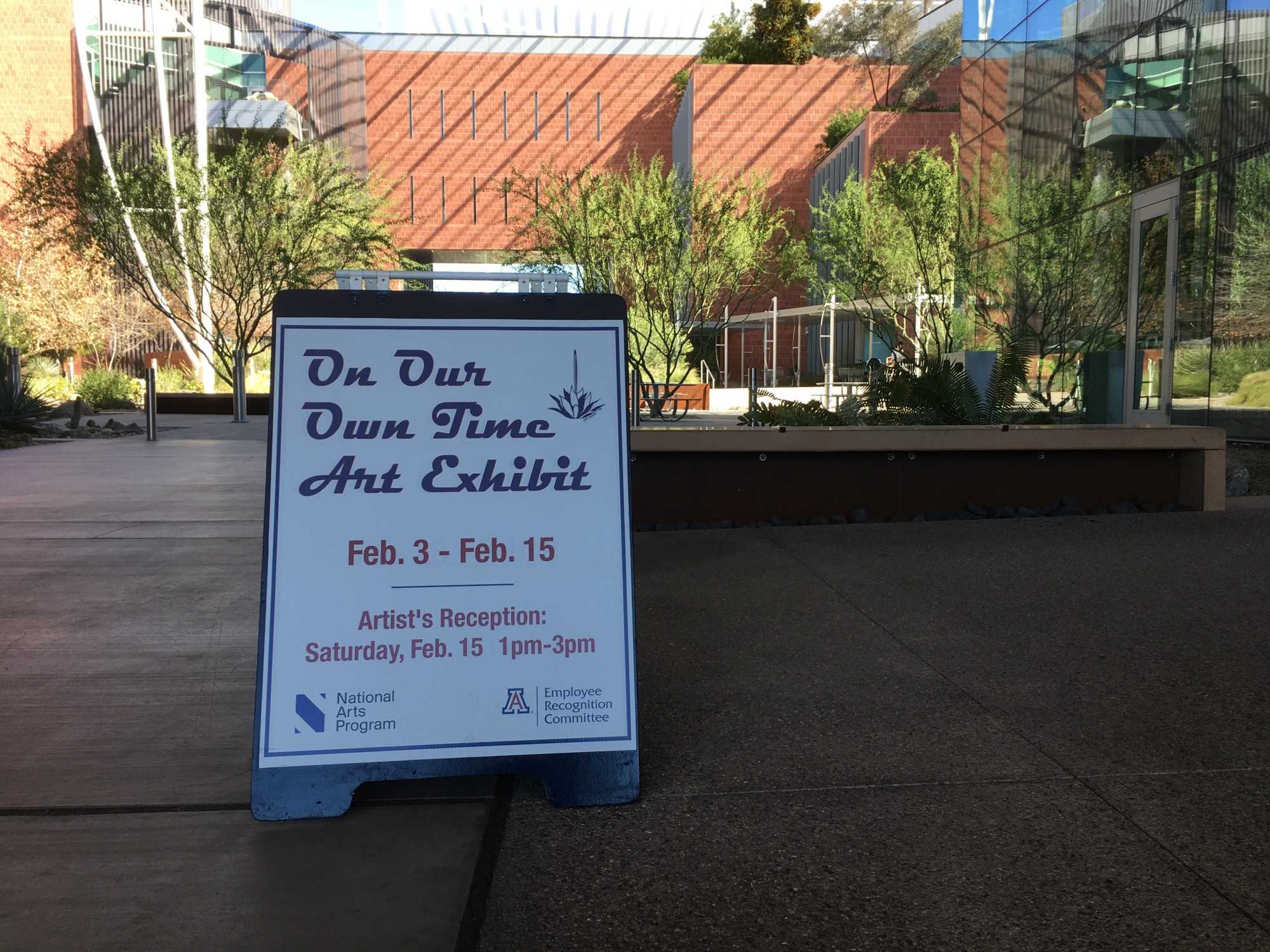 The "On Our Own Time" art exhibit sign, pointing visitors into the direction of the Bio-sciences Research Lab, where the event took place.