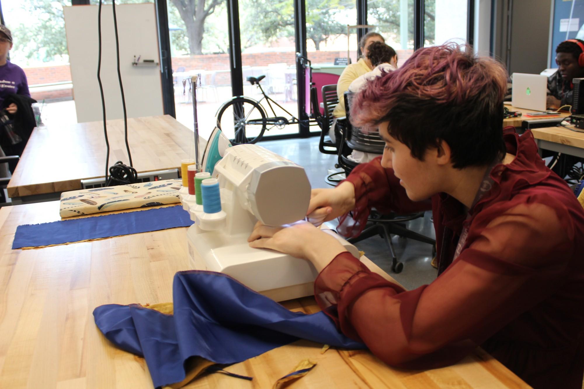 Katherine Davis, a student is using a  sewing machine.