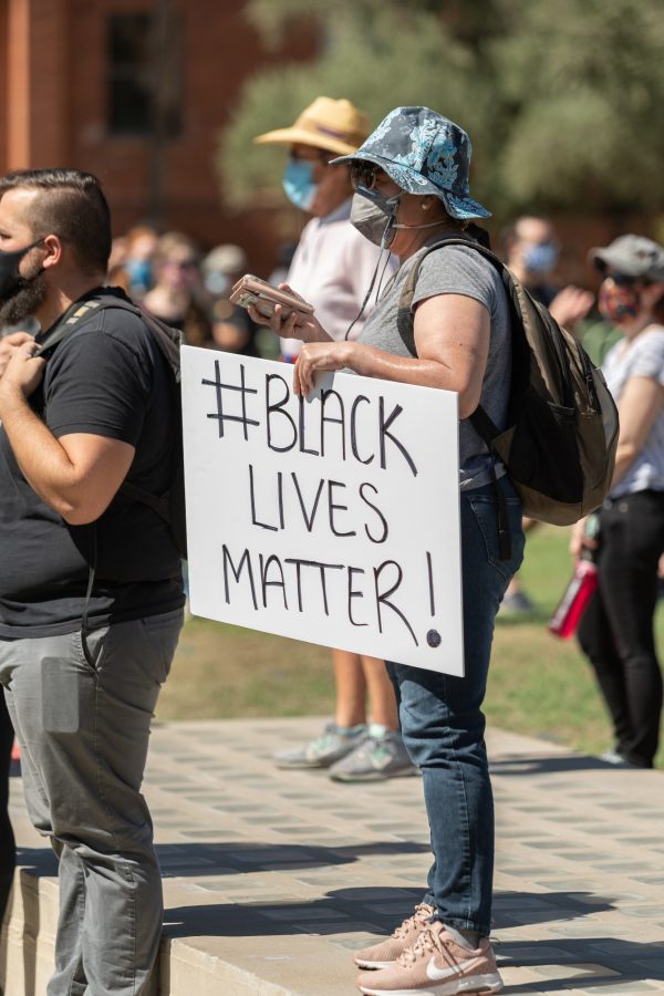 Local Tucson protester holding up a sign with the words #Black Lives Matter! written on it.