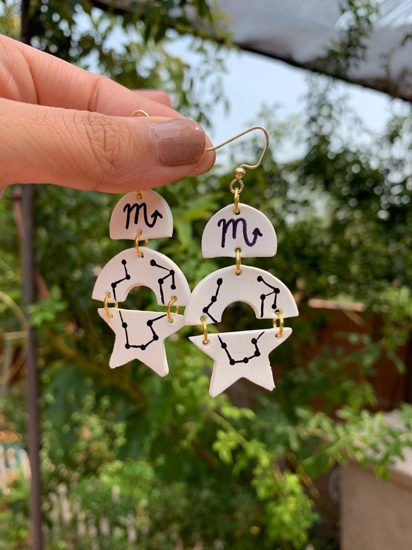 A pair of Itzel Herrera's zodiac earrings she designed for her business, Wearing Confetti. Herrera also features her best friend, Sandy Trieu's business, Sis and Stitches, on her business account and vice versa. (Photo Courtesy Itzel Herrera) 