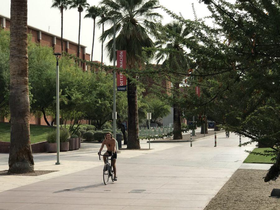 Unmasked person rides a bike at the University of Arizona on Monday, Sept. 14, 2020, in Tucson, Ariz. (Photograph by Diana Ramos)