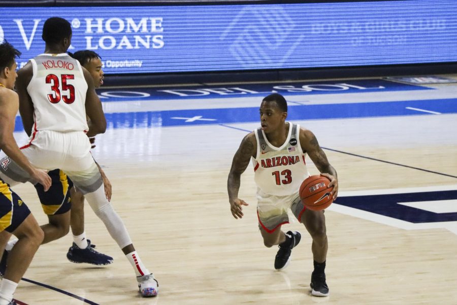 Number 13 James Akinjo a junior on the University of Arizona’s men’s basketball team dribbles left as his teammate number 35 Christian Koloko sets a screen for him in McKale Center, Monday, Dec. 7, 2020. The Wildcats went on to win the game 96-53.