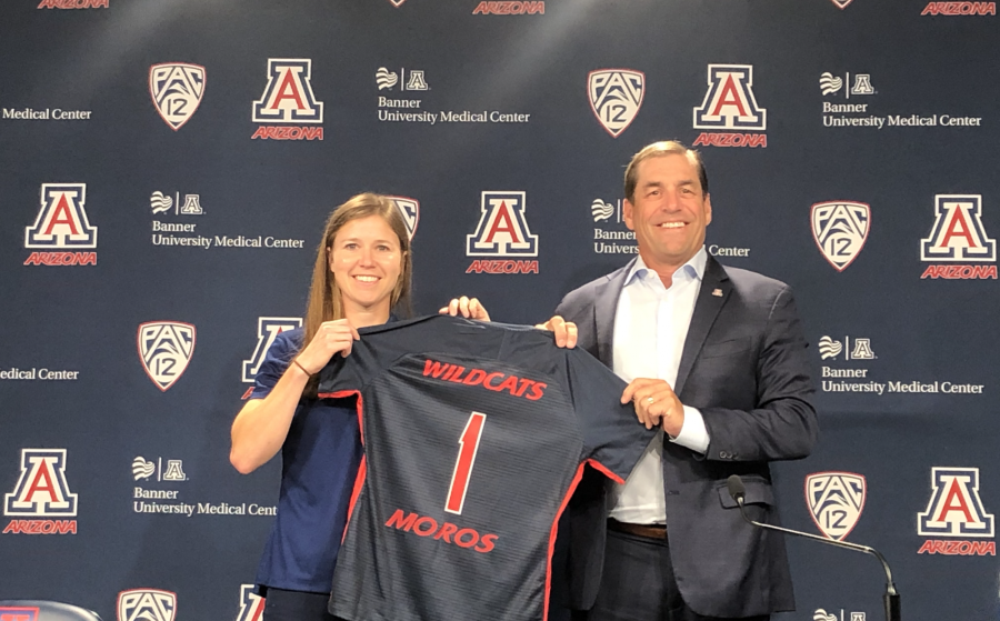 Arizona soccer head coach Becca Moros (left) and Arizona Athletic Director Dave Heeke (right) hold up an Arizona soccer jersey during Moross introductory press conference in McKale Center on July 19, 2021.
