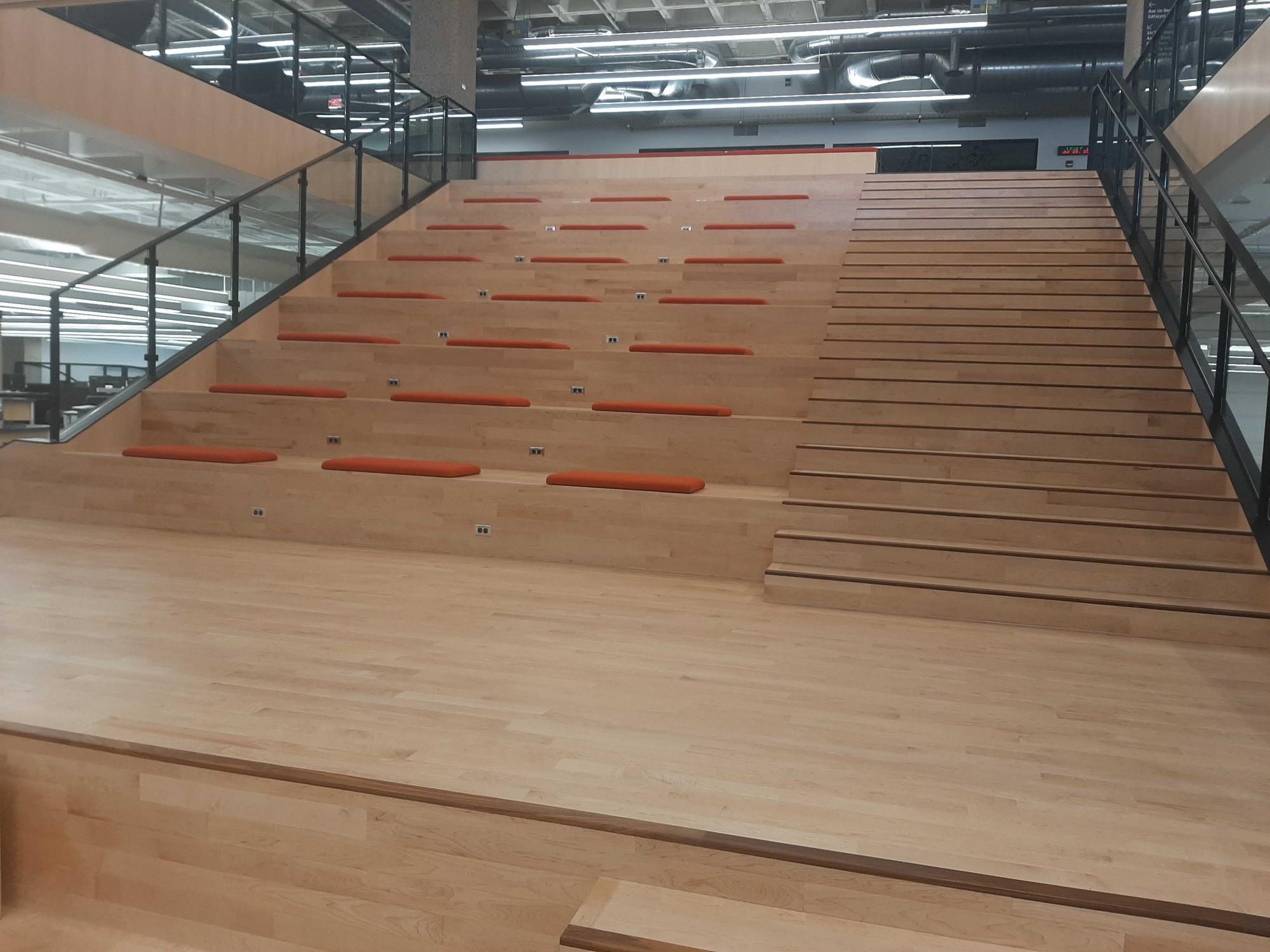 The new staircase in the Main Library connecting the first and second floors in the large study room on July 20. The staircase also doubles as classroom space, with orange cushions for seating and a dropdown projector board at the bottom.