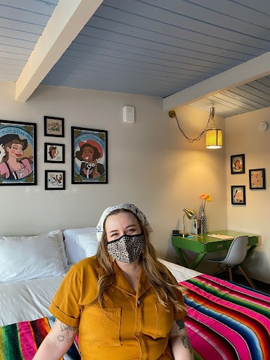 Artist Krista Nicole sits in their eponymous Krista Nicole Room displayed inside of Hotel McCoy. The room features Nicole's art series titled " A Cowboy for Breakfast." (Courtesy Krista Nicole) 