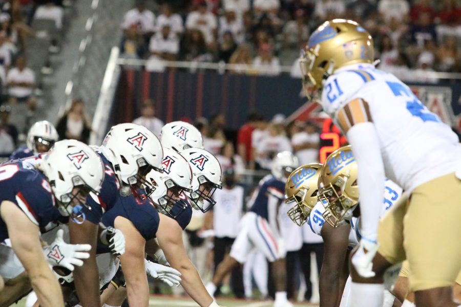 The Arizona offensive linemen line up against the UCLA defense prior to the play in Arizona Stadium on Oct. 9. The Arizona offense gained 219 yards in the first half against UCLA. 
