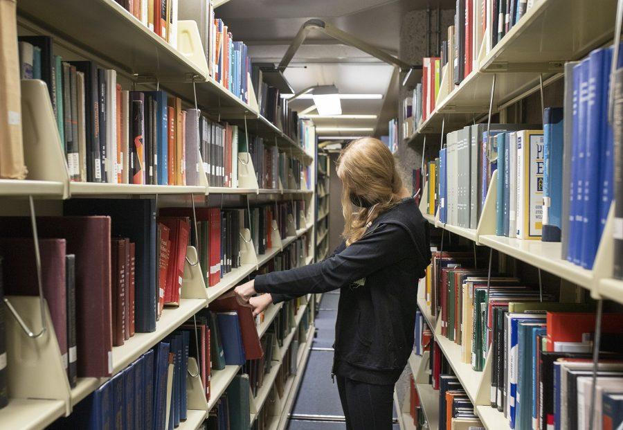Sophomore Lucy Sieczka searches for a book inside of the University of Arizona Main Library on Nov. 10. The library contains over eight million print volumes, electronic books and journals in its collection, all of which are available for student rental.